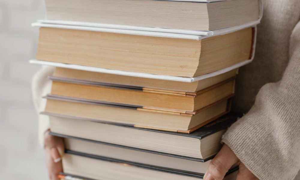 gros-plan-des-mains-tenant-la-pile-de-livres